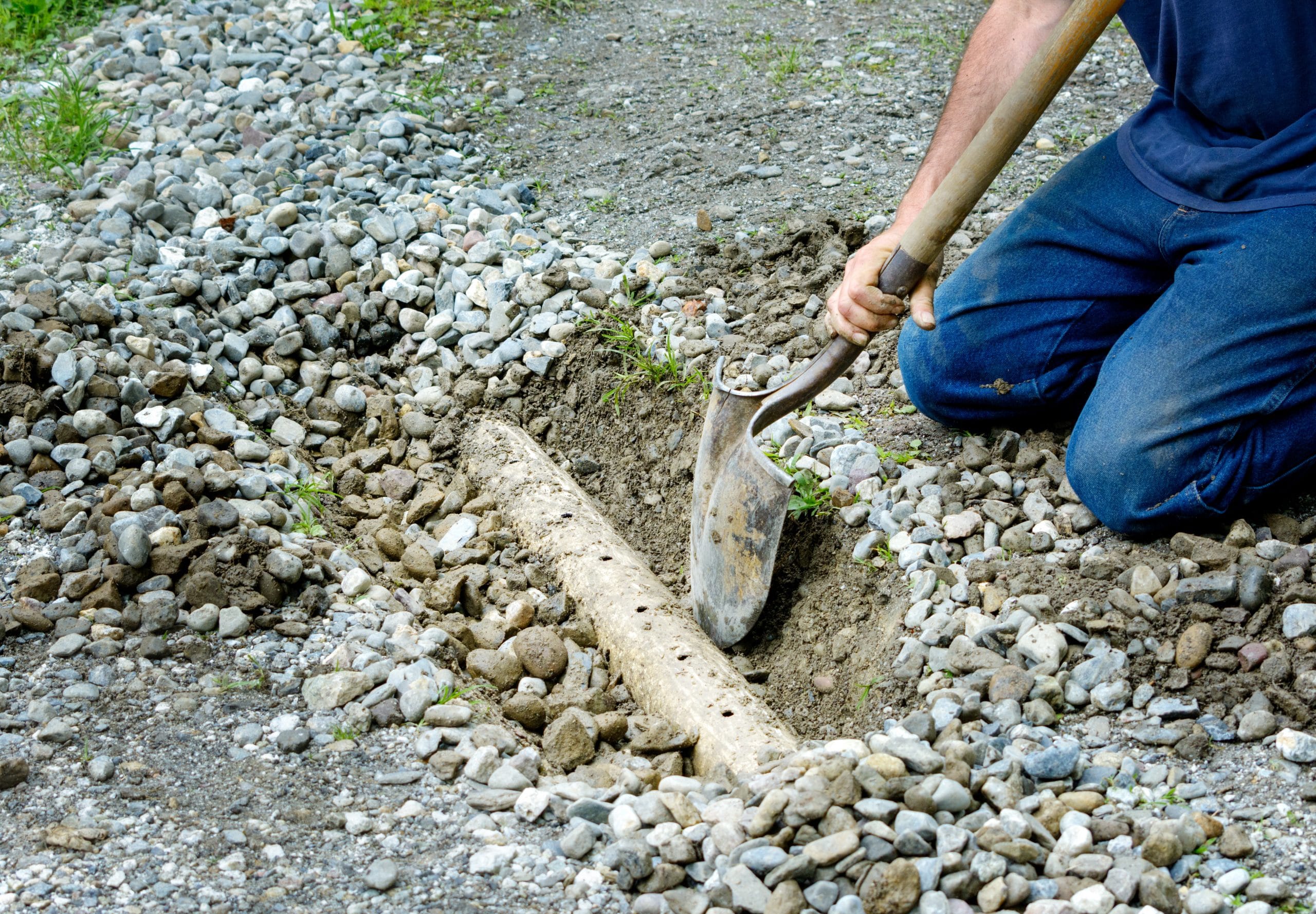 Man digging out french drain