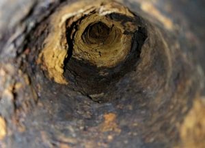 The rusty insides of an old sewer pipe.